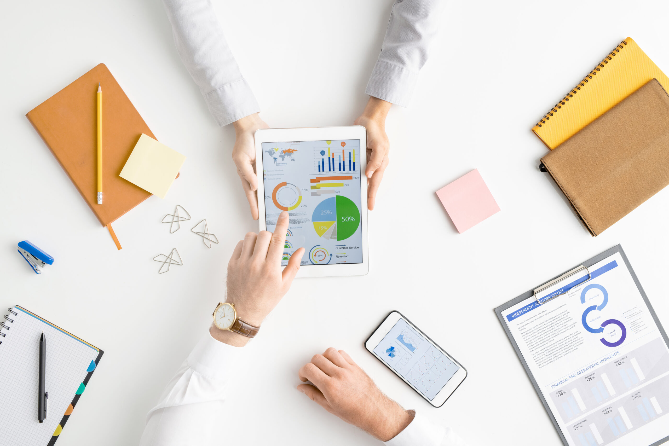 View of hands of two contemporary Bookkeepers and graph